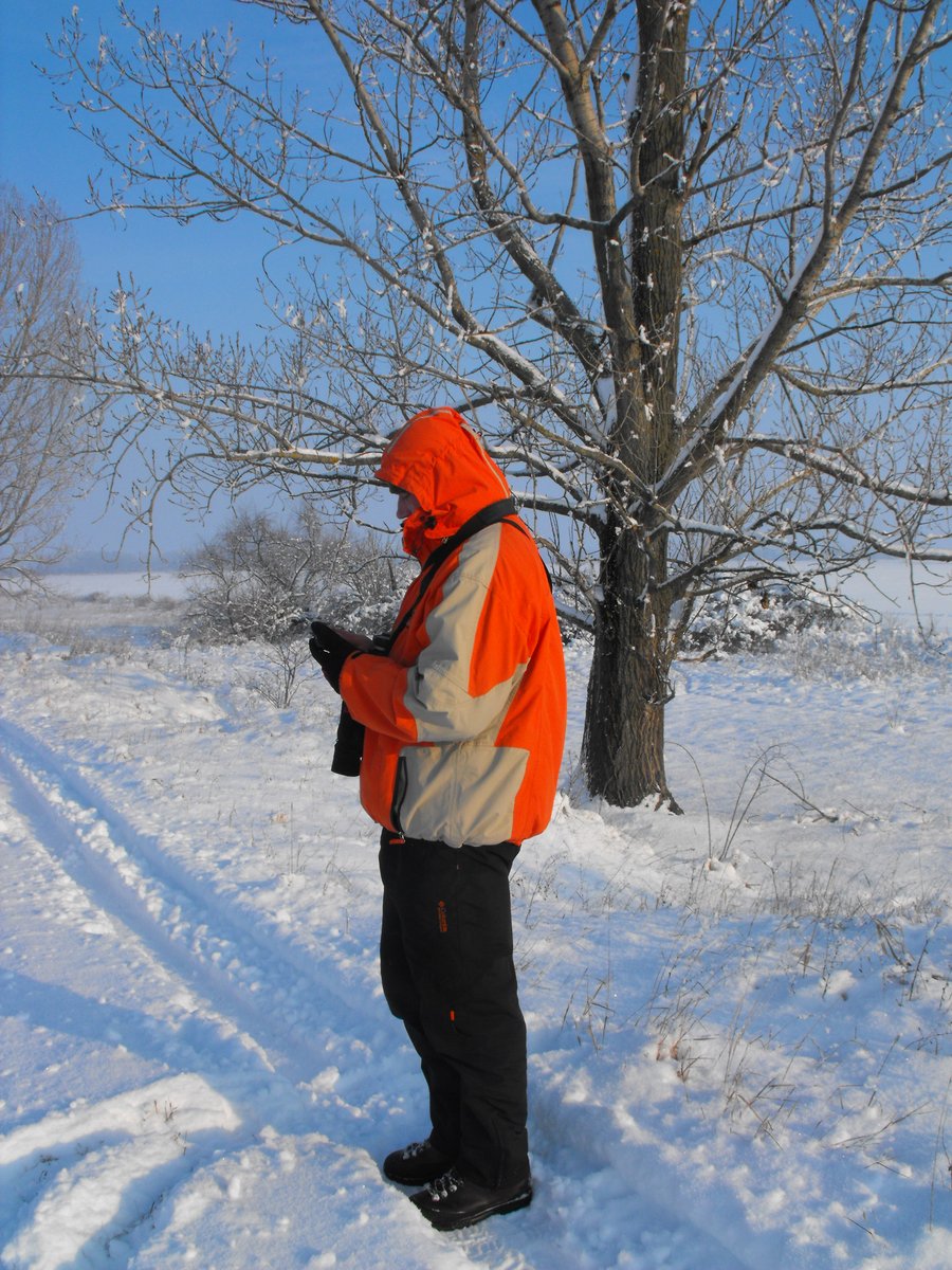 Egy férfi a mobilján dolgozik a havas tájban