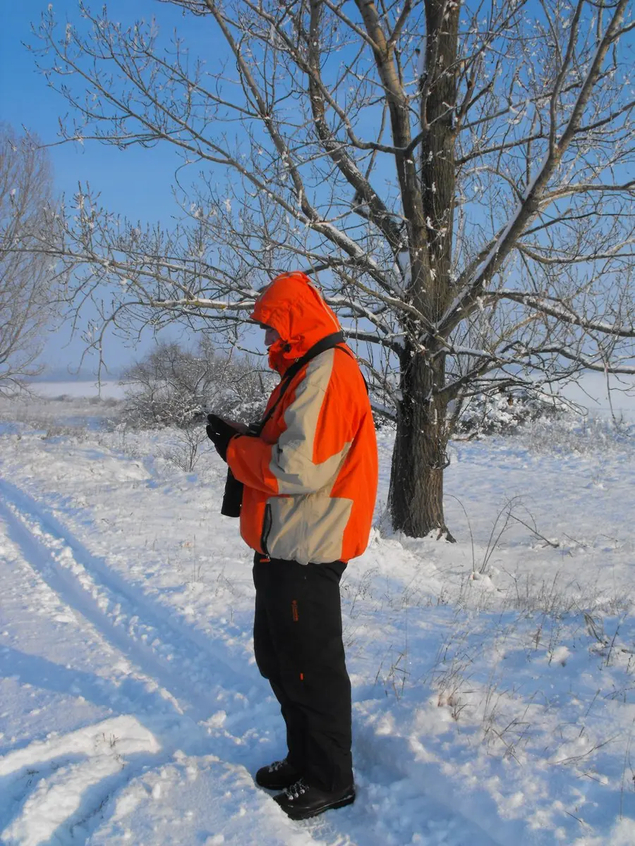 Egy férfi a mobilján dolgozik a havas tájban