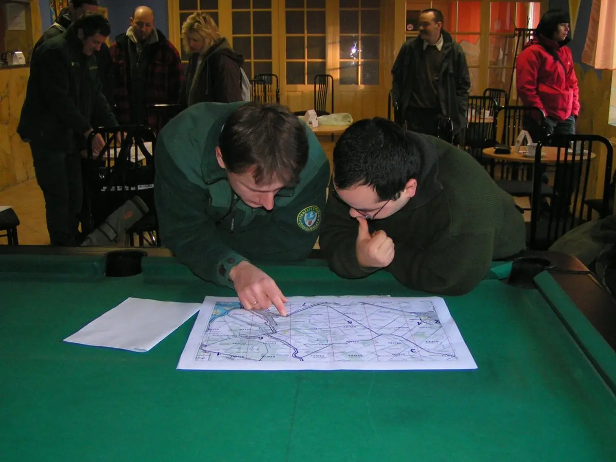 Emberek beszélgetnek egy térkép fellett egy kocsmában