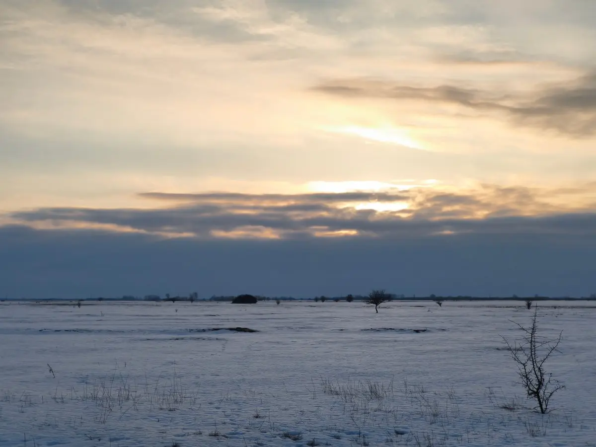 Naplemente a behavazott síkvidéki tájon